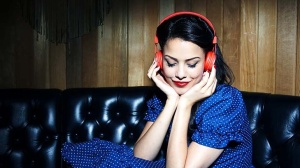 young woman listening to music wearing headphones